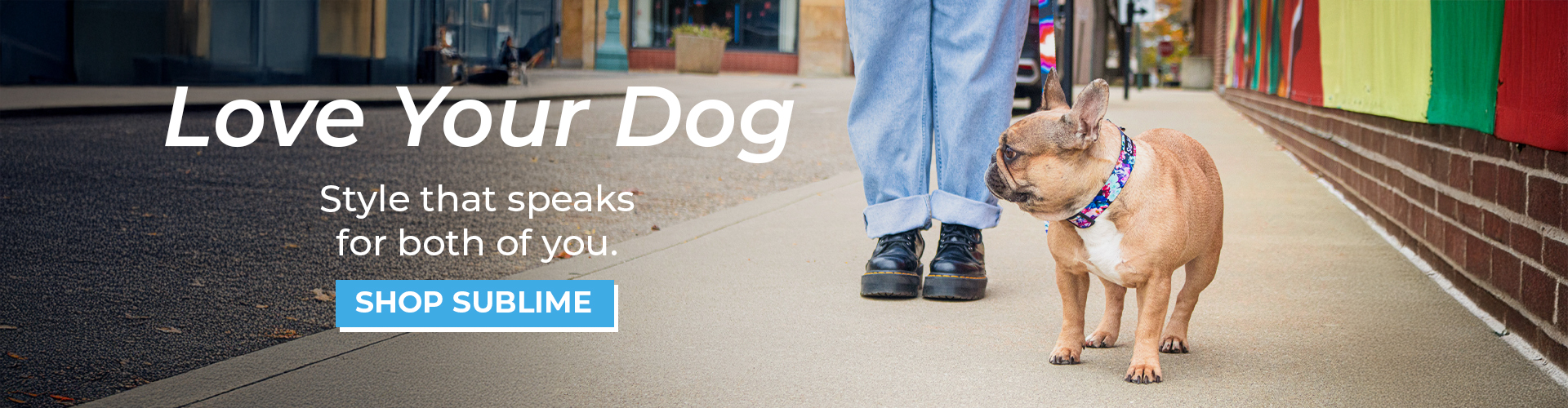 Banner reading “Love Your Dog,” “Style that speaks for both of you,” and “Shop Sublime.” A French bulldog wearing a colorful Sublime collar and leash stands on a city sidewalk beside a person in rolled‑up jeans and black shoes.