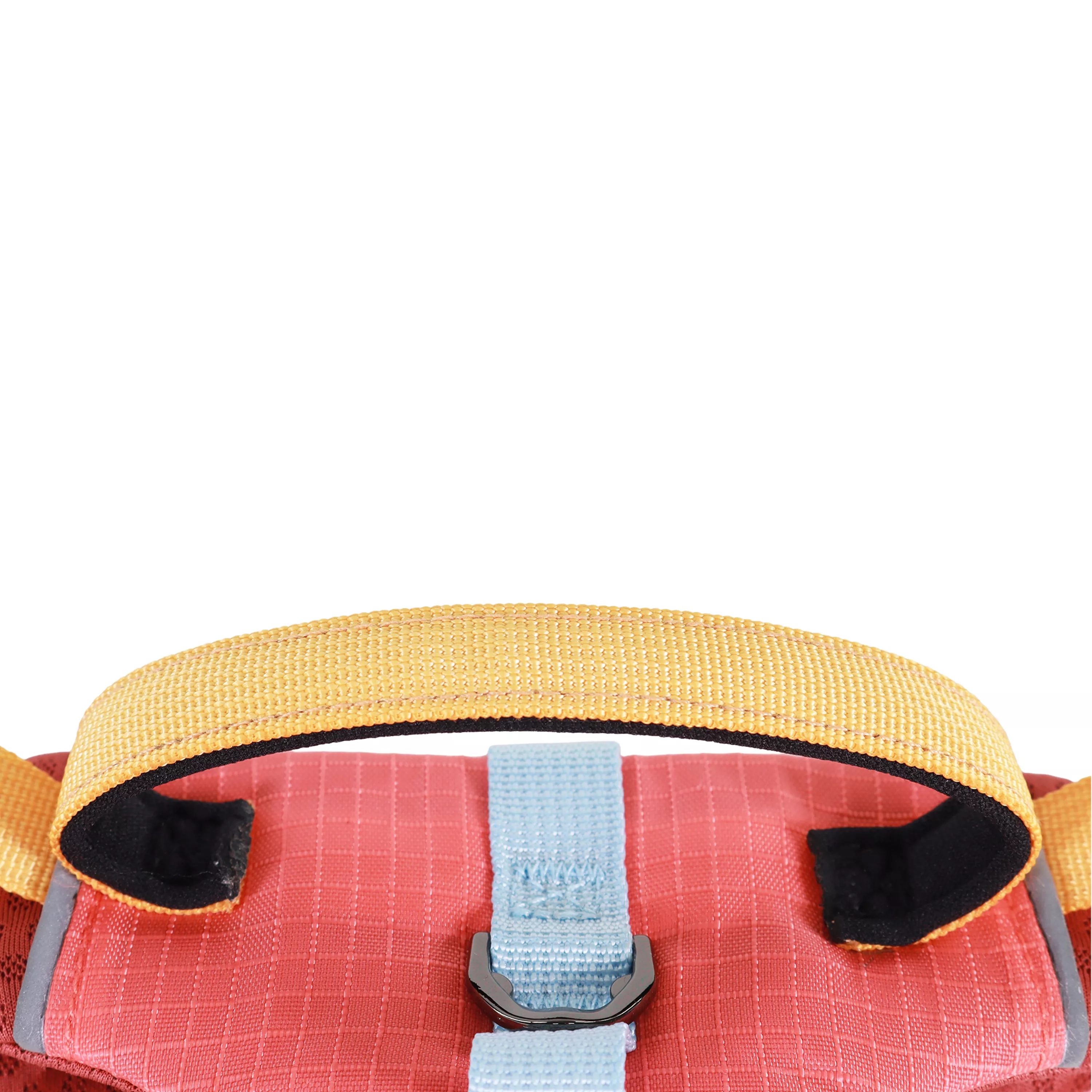 A close‑up view of the top section and handle of a Mojave‑colored dog harness is shown against a white background. A yellow woven handle spans the top of the harness with reinforced stitching along its base. Beneath the handle is a burnt‑orange fabric panel with a grid‑stitched pattern. A gray woven strap runs vertically under the handle and is sewn into the panel.