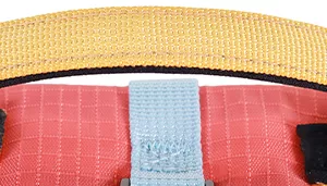 A swatch featuring a multi‑band textile design in warm desert tones. The upper section is a muted mustard‑gold fabric with a coarse, textured weave. Below it is a narrow band of smooth light blue material bordered by thin black seams. The bottom portion transitions into a matte red‑orange band. Together, the colors evoke a sunset‑inspired desert palette.