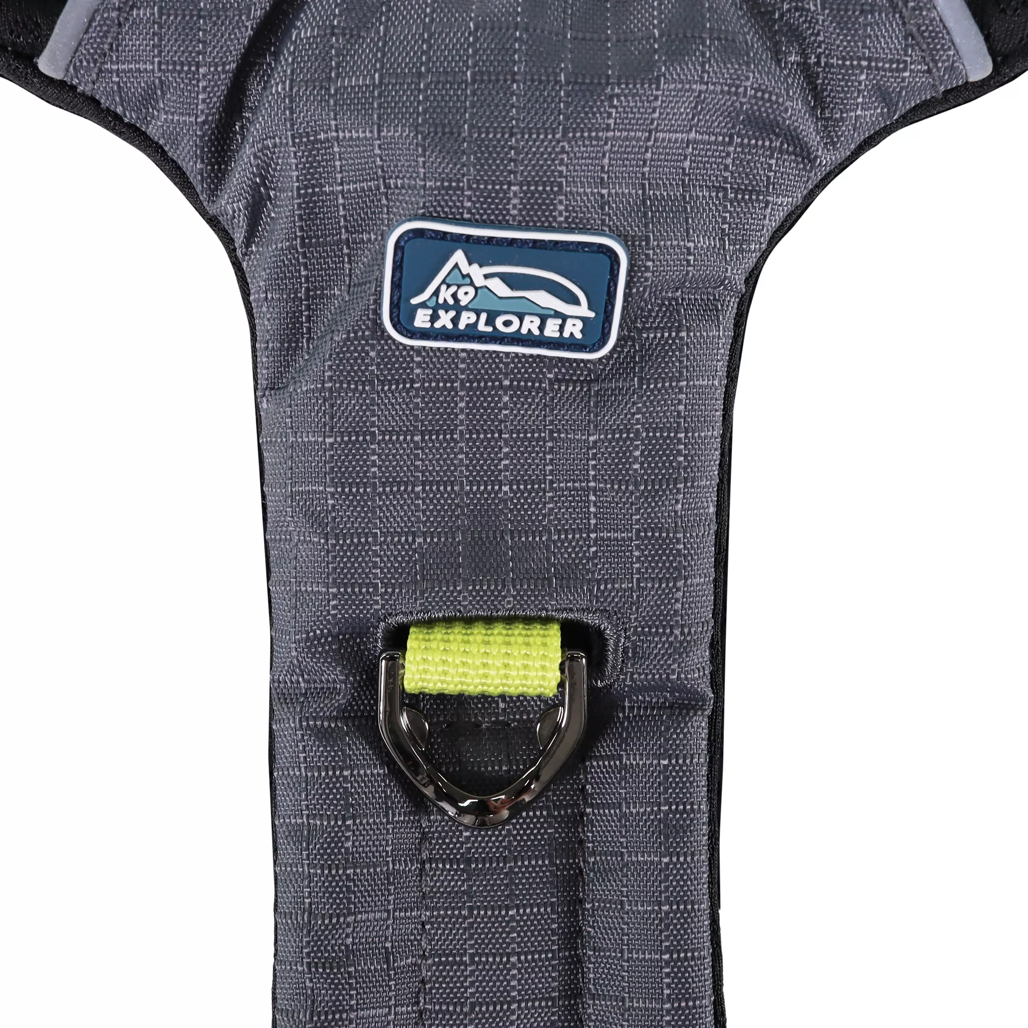 A Boulder full‑coverage harness is displayed against a white background. The central panel has charcoal gray fabric and reinforced stitching. A black metal D‑ring is attached near the top center where a green webbing strap is stitched into the body of the harness. A woven brand label is placed above the D‑ring.